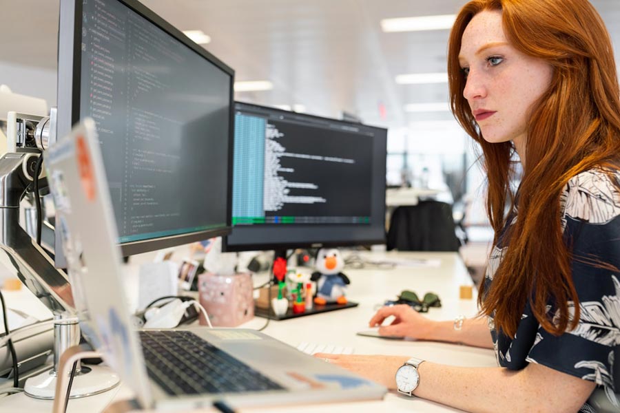 A woman in an office researching newsletter software on her computer